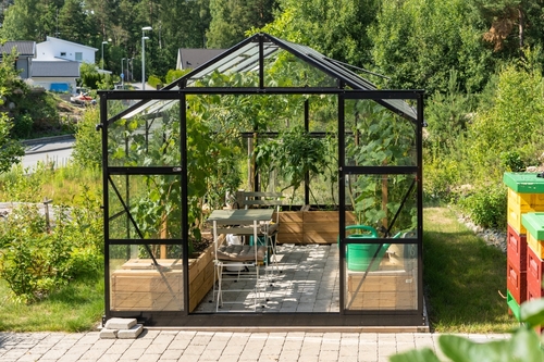 Billede af et drivhus i glas i have